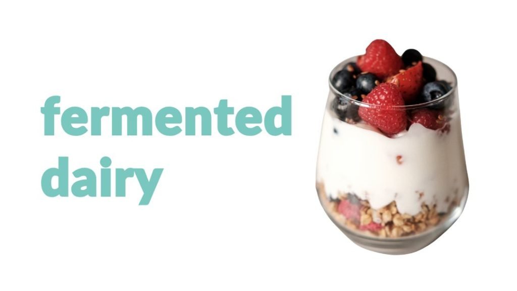 a glass container with yogurt and berries and granola
