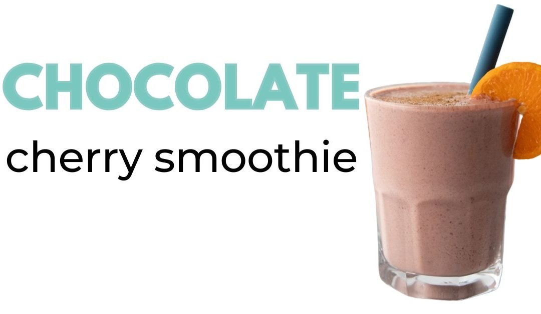chocolate cherry smoothie in glass cup with an orange slice on the rim